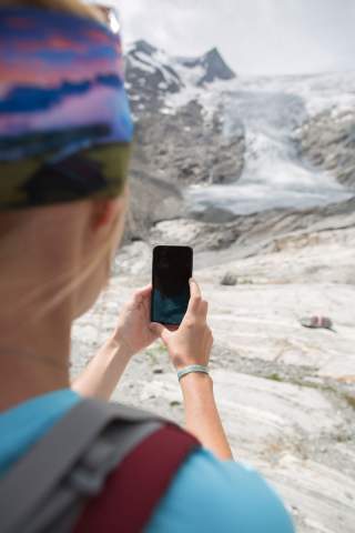 Frau fotografiert Gletscher mit Handy