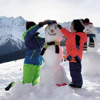 Zwei Kinder bauen einen Schneemann
