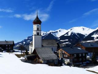 Kleines Bergdorf im Winter mit Kirche