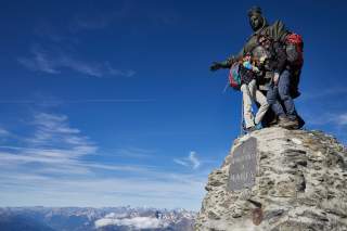 Zwei Wanderinnen mit Madonnastatue auf Gipfel