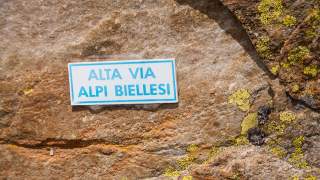 Fels mit Wegweiser Alta Via Alpi Biellese