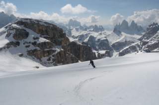 Skifahrer bei Abfahrt mit Blick auf Gipfel
