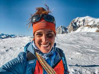 Tamara Lunger macht ein Selfie von sich in der eisigen Winterlandschaft bei strahlend blauem Himmel.