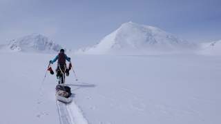 Astrid Därr zieht eine Art Kanu auf Ski nach sich. Rundherum ist alles weiß und von Schnee bedeckt.