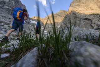 Zwei Menschen wandern in alpinem Gelände