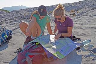 Zwei Wanderinnen studieren Karte am Berg