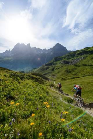 Zwei Menschen auf Mountainbikes fahren Trail in den Bergen