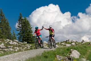 Zwei Mountainbikerinnen auf einem Forstweg