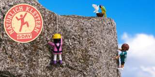 Playmobilmännchen an Stein mit Natürlich klettern-Logo