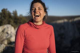 Portrait von der lachenden Nina Caprez in rotem Longsleeve.