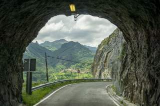 Blick aus Tunnel in grüne Berglandschaft