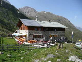 Kleine Berghütte in Berglandschaft bei Sonnenschein