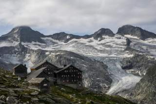 Eine sehr markante Alpenvereinshütte Hütte mit sechs Giebeln, vor einem Gletscher gelegen.