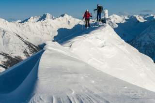 Zwei Skitourengehende auf einem schneebedeckten Bergkamm