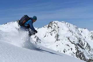Skifahrer bei Abfahrt im Powder