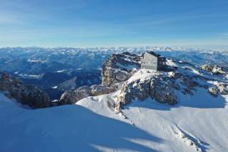 Futuristisch anmutende Berghütte im Winter vor Gipfelmeer