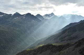 Berglandschaft mit durch Wolken blitzende Sonnenstrahlen