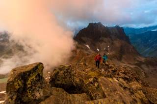 Zwei Wandernde im Hochgebirge mit aufziehenden Wolken