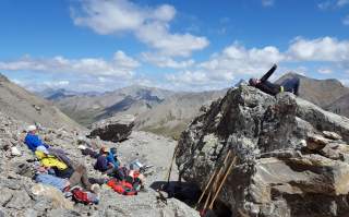 Gruppe von Menschen macht Pause in alpinem Gelände