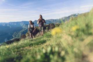 Ein Paar wandert auf frühlingshafter Bergwiese