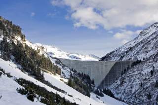 Massive Staumauer in winterlicher Berglandschaft