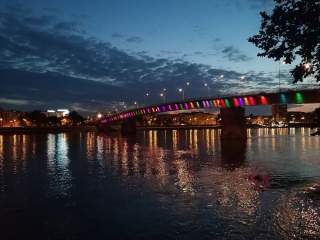 Bunt leuchtende Brücke in Stadt über Fluss