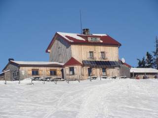 Holzhütte mit rotem Dach im Winter