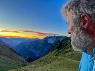 Mann genießt Sonnenaufgang in den Bergen