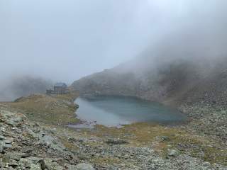 Die Flaggerschartenhütte mit See im Nebel