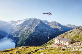 Helikopter beliefert Hütte in den Bergen