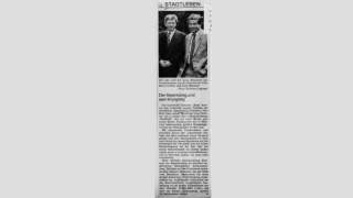 Scan eines Zeitungsartikels. Es zeigt ein Schwarz-Weiß-Foto von zwei Männern, darunter einen kurzen Beitrag.