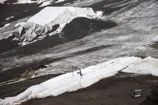 Weiße Planen bedecken Schnee und Gletschereis in sonst schneefreier felsiger Hochgebirgslandschaft