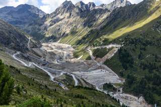 Grünes Tal in den Alpen wird ausgebaggert