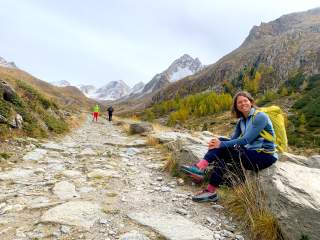 Bergführerin Michaela Egarter sitzt auf einem Stein in Bergumgebung
