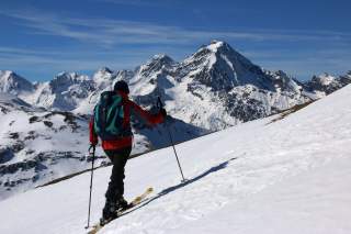 Skitourengeher beim Aufstieg mit Blick auf Bergkulisse