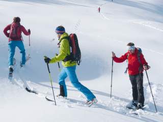 Gruppe von Menschen auf Skitour beim Bogentreten