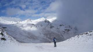 Alfred steht am Beginn der Tour; es liegt Schnee, im Hintergrund Berge.
